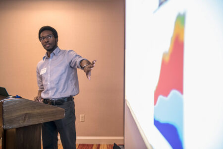 A student gestures to a projection showing a graph.